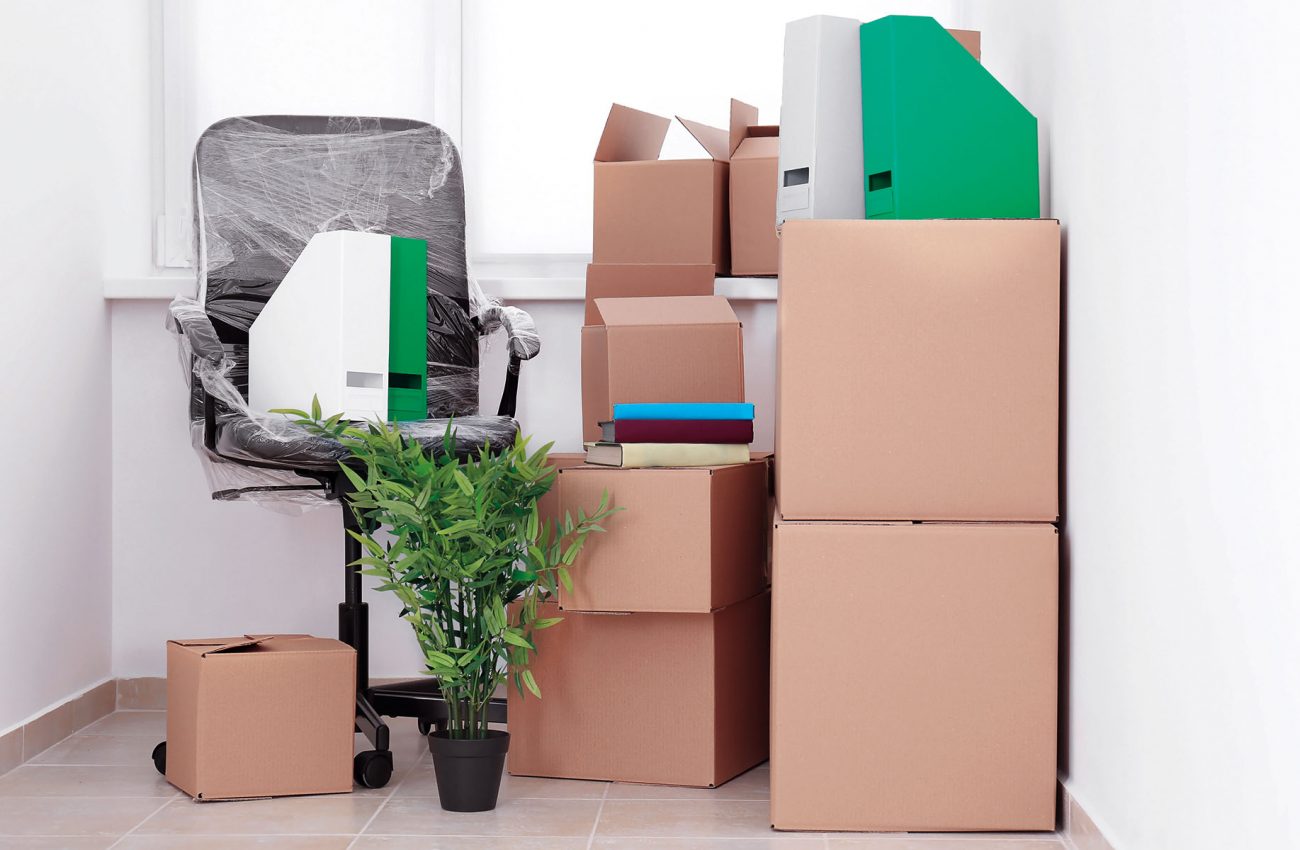 Office move concept. Carton boxes and chair on floor in empty ro