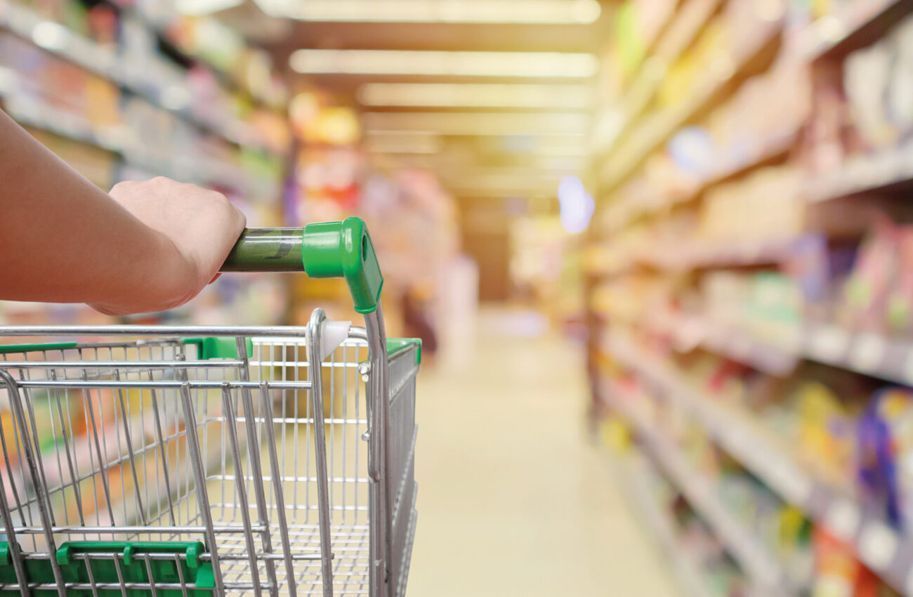 shopping cart in supermarket aisle with product shelves interior