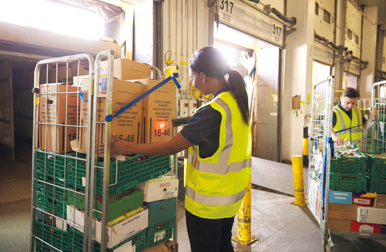 Man prepares and scans packages in a warehouse for delivery