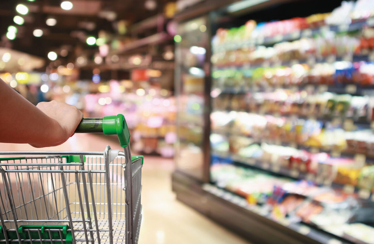 woman hand hold supermarket shopping cart with Abstract grocery